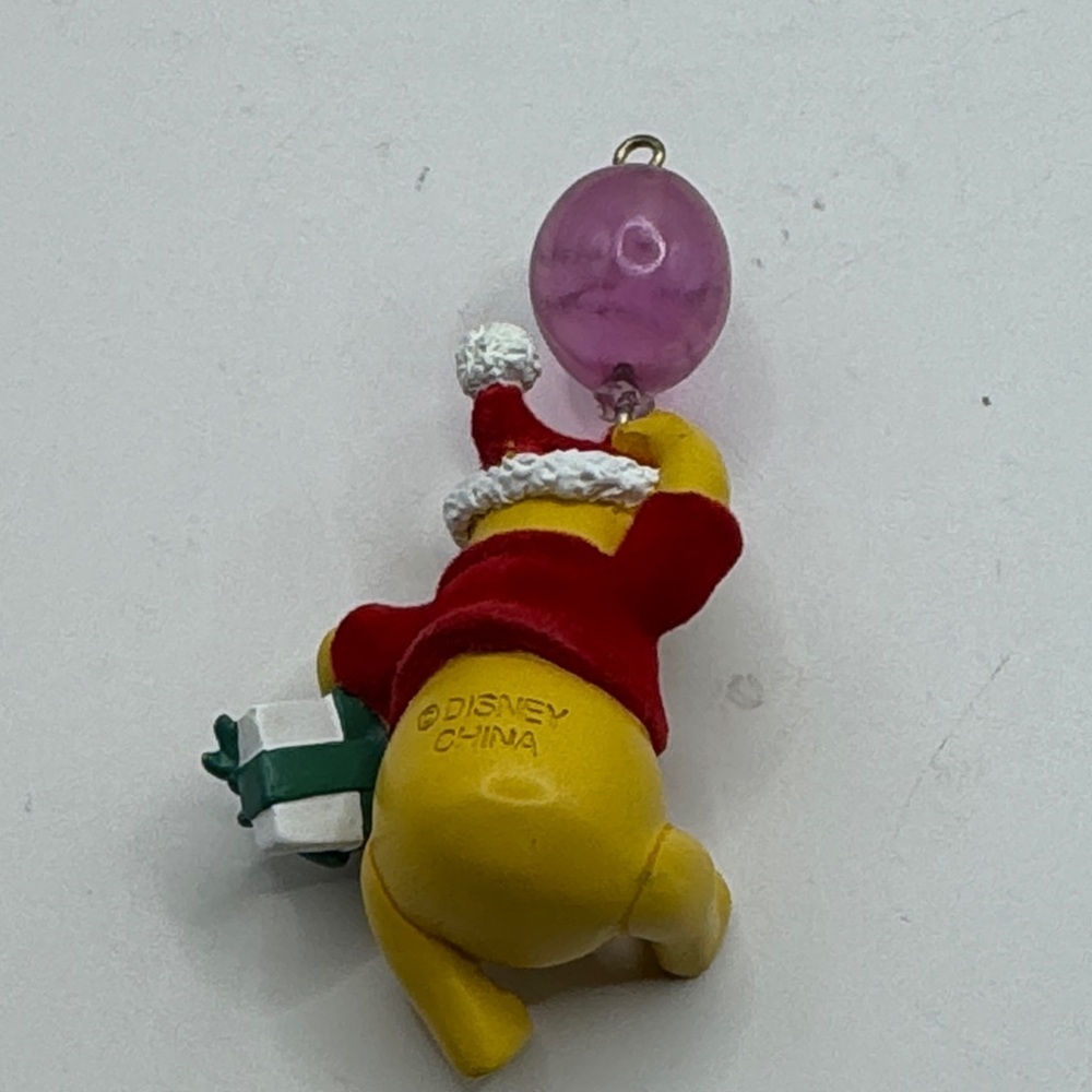 Winnie the Pooh figure ornament holding a balloon that says Merry Xmas - Picture 2 of 4